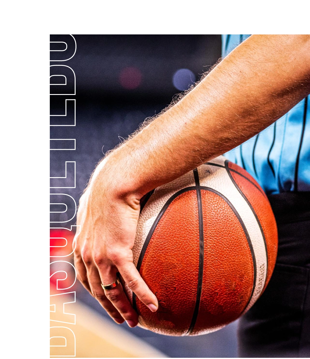 Close-up de um jogador de basquetebol a segurar uma bola de basquetebol, destacando foco e prontidão para jogar.